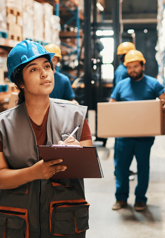 Workers' compensation safety consultant at job site with protective gear.